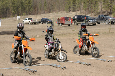 Three dirt bike riders line up in the starting gate