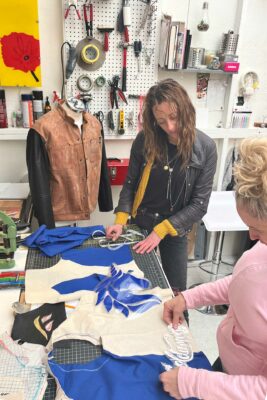 Leather clothing designer works with client on a vest project.