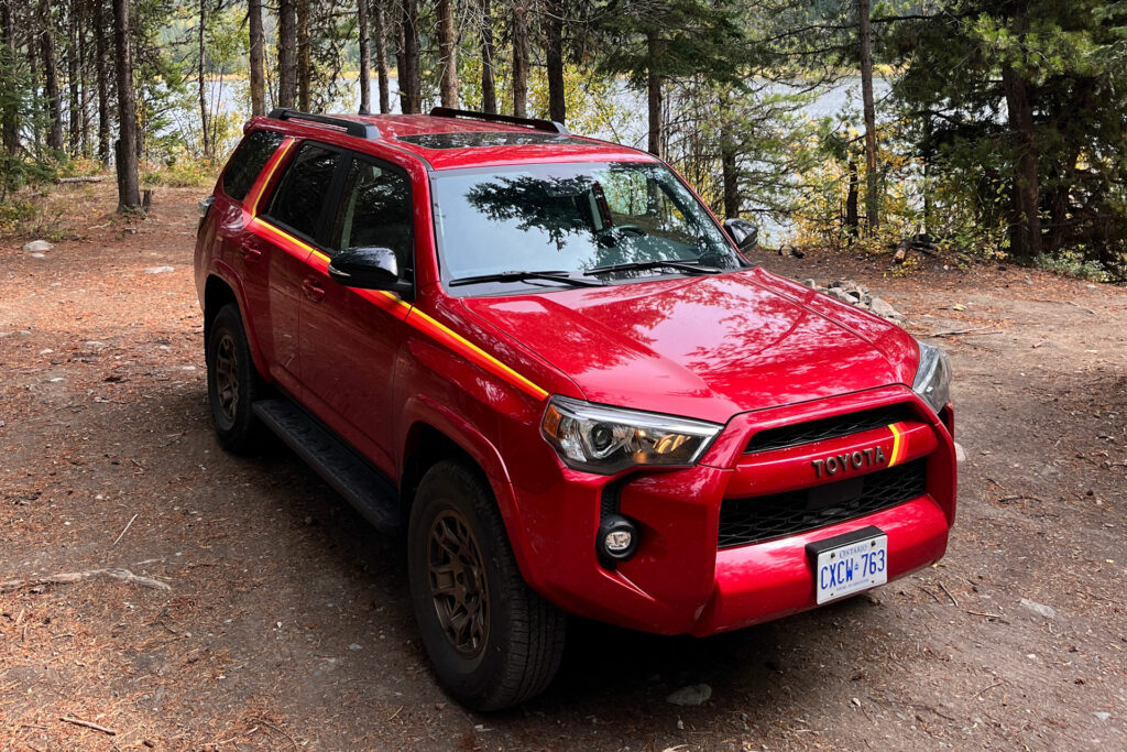 2023 40th Anniversary Toyota 4Runner in Barcelona Red parked in the woods beside a lake