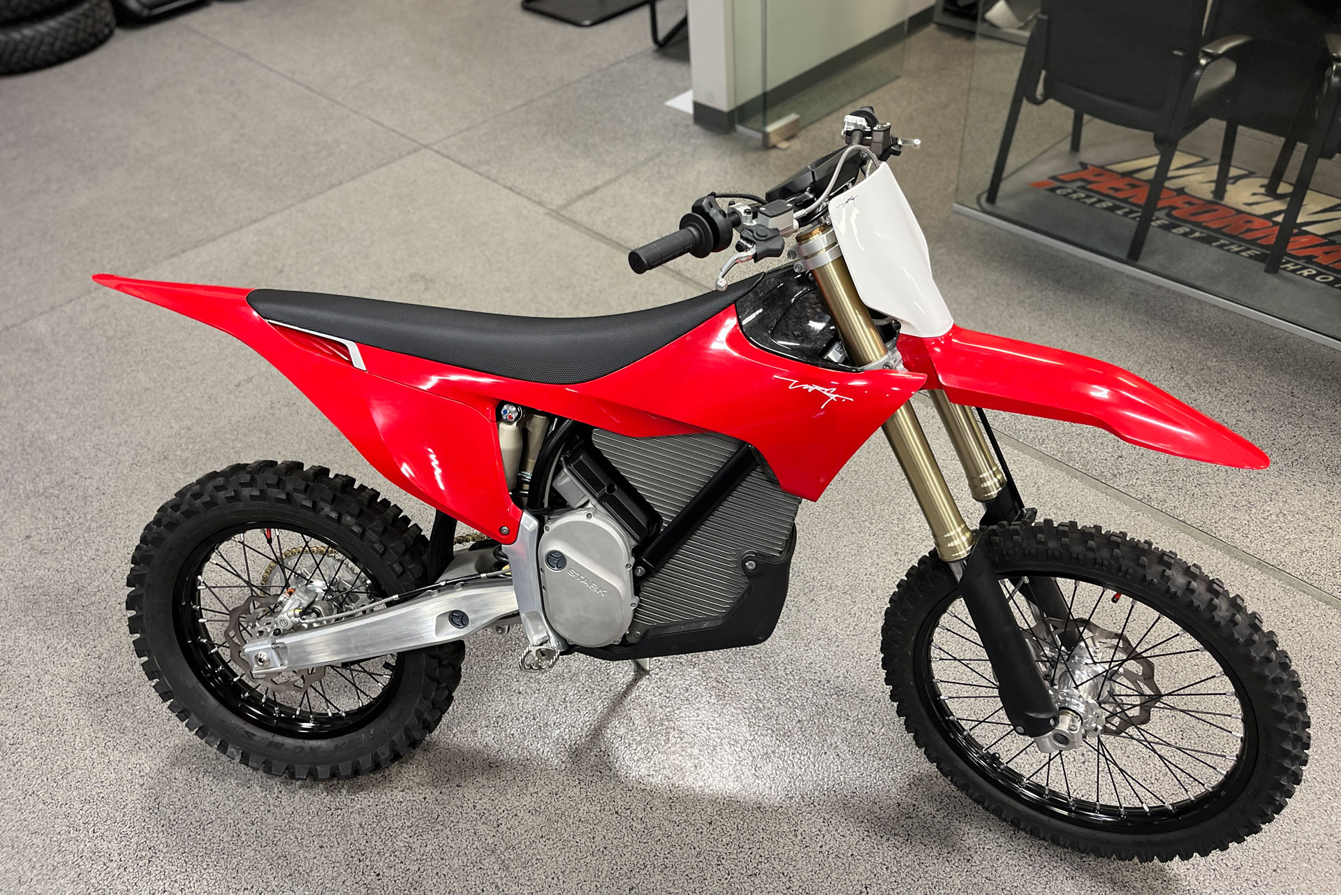 The VARG motocross bike from Stark Future stands in a showroom,