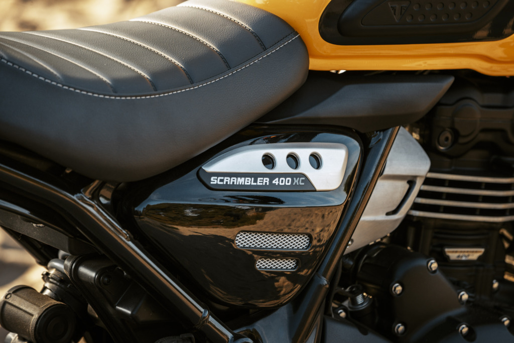 Triumph Unveils the All New 2026 Scrambler 400 XC 10 a close up view of a side panel of a motorcycle that reads Scrambler 400 XC