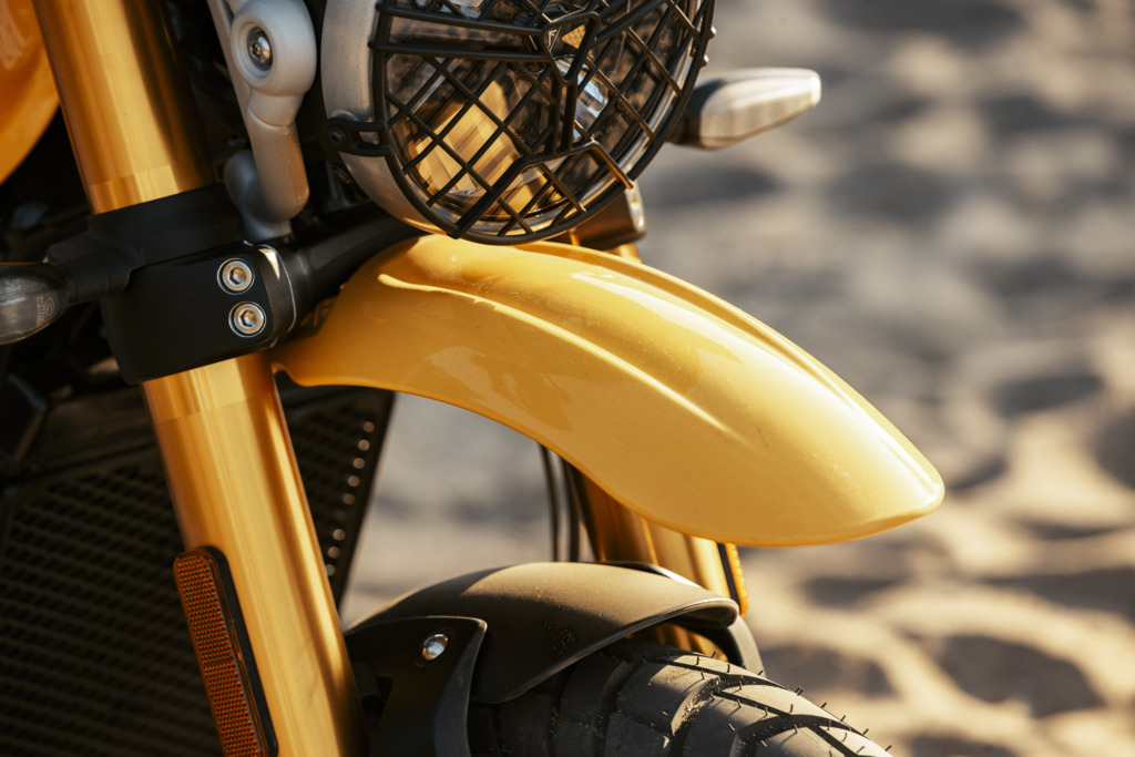 Triumph Unveils the All New 2026 Scrambler 400 XC 13 a close up of the front fender and headlight of an off-road motorcycle