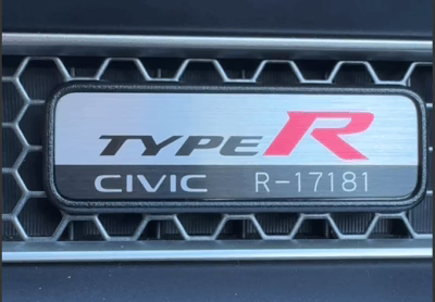 a metal plate mounted on the interior vehicle grill that reads Type R Civic R-17181