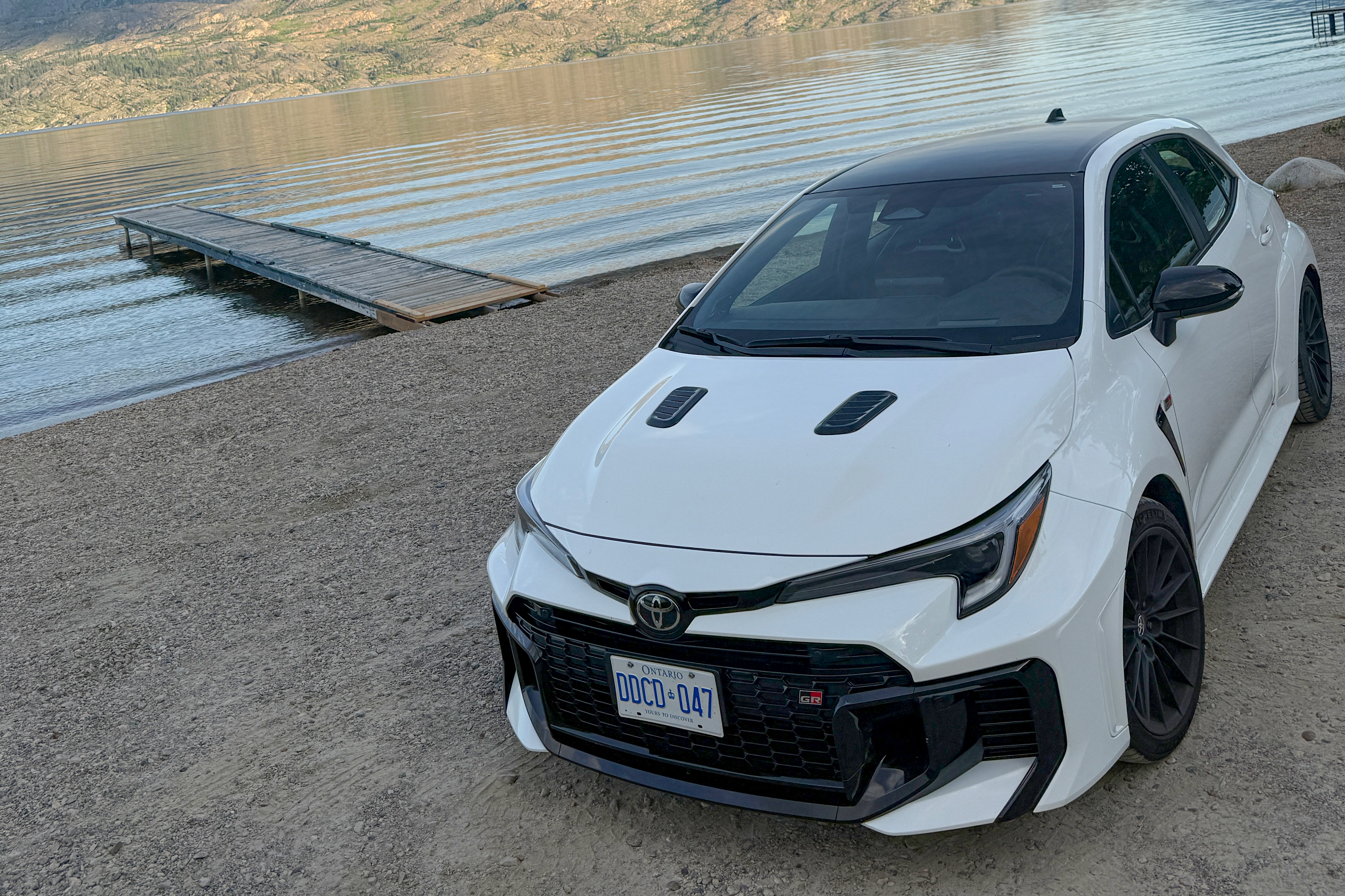 2025 Toyota GR Corolla 1 a white car parked alongside a lake