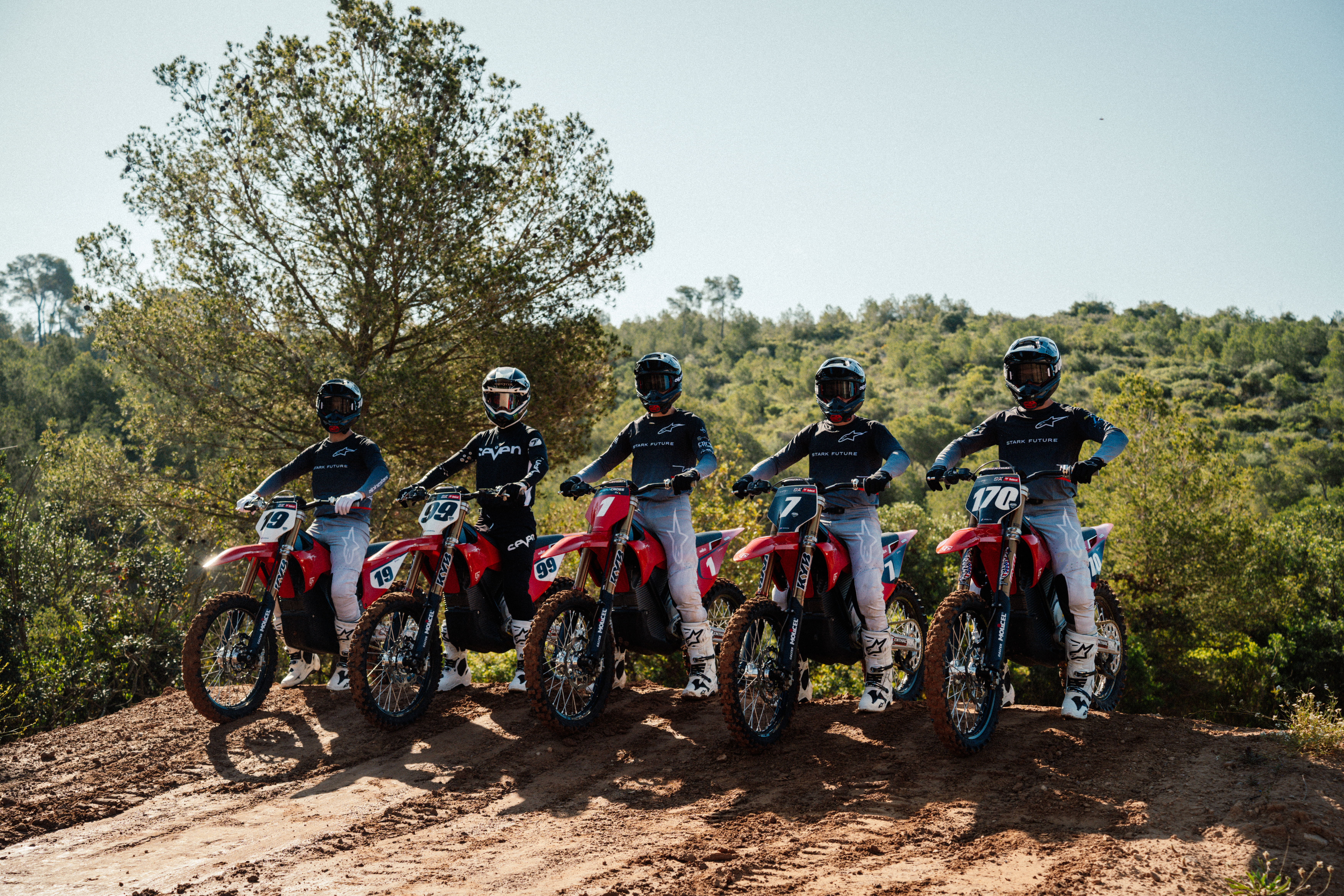 Stark Supercross race team members pose seated on their Varg MX bikes on the track
